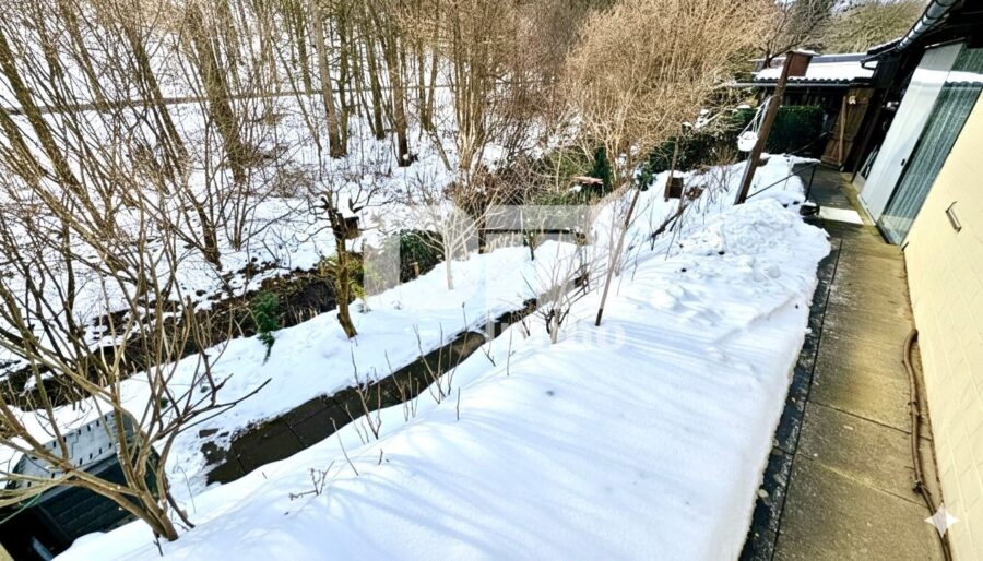 Modernisierte DHH mit Doppelgarage und 2x Carport in Traumlage inkl. Bachlauf - Gartenbereich hinter den Carports mit Bachlauf